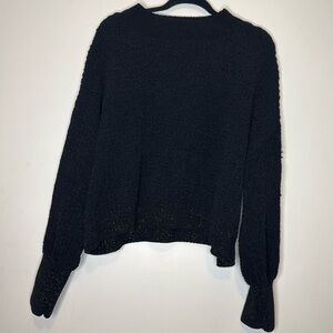 Design history, black knitted sweater with shimmer sleeve cap and bottom hem